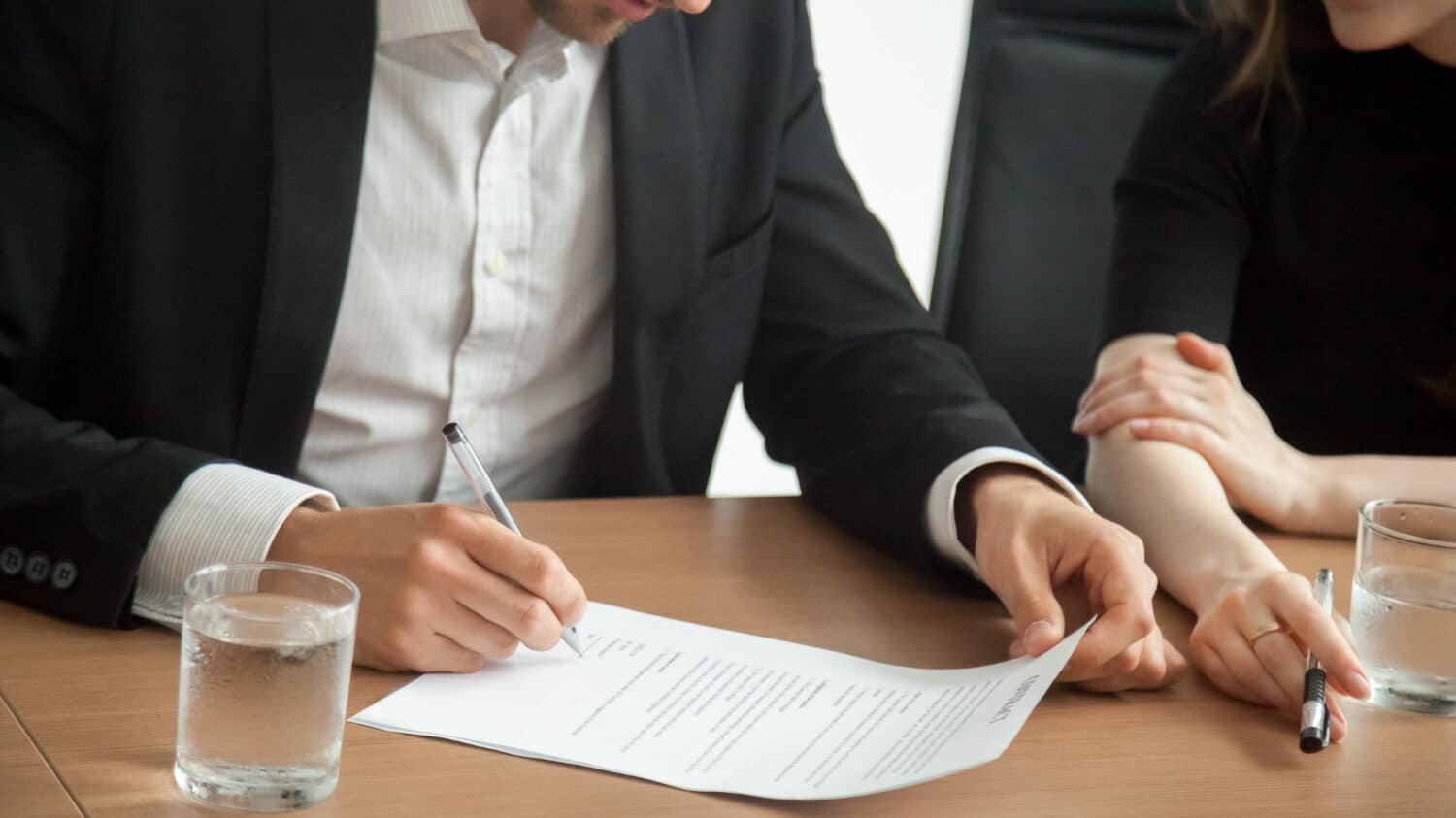 Imagem de um homem assinando um documento, representando o fechamento de um contrato com Advogado Trabalhista